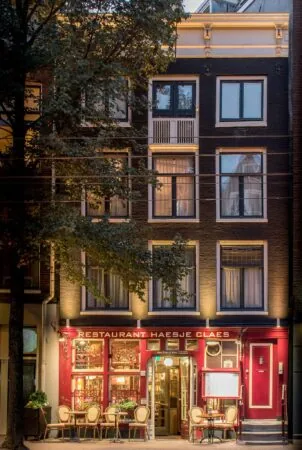 Restaurant Haesje Claes aan de Nieuwezijds Voorburgwal in Amsterdam, sfeervol verlicht met zitplaatsen buiten.